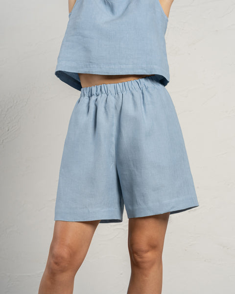 Bermudashort van linnen in de kleur wolkachtig blauw. Hooggetailleerde langere short met zakken en elastische tailleband.