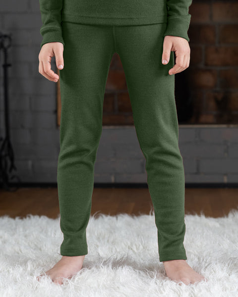 Child wearing merino wool menique leggings in the color dark green