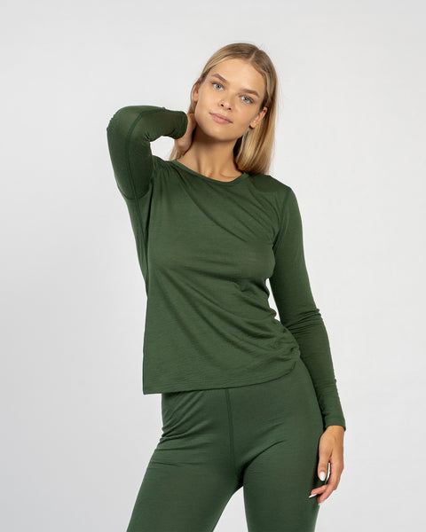 Het donker groene lange mouwen shirt van merinowol voor dames van menique, gecombineerd met donker groene broek van menique, van voren gezien.