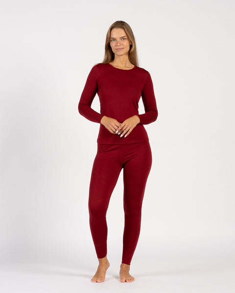 Woman modeling Merino wool thermal top and leggings in royal cherry, relaxed stance.