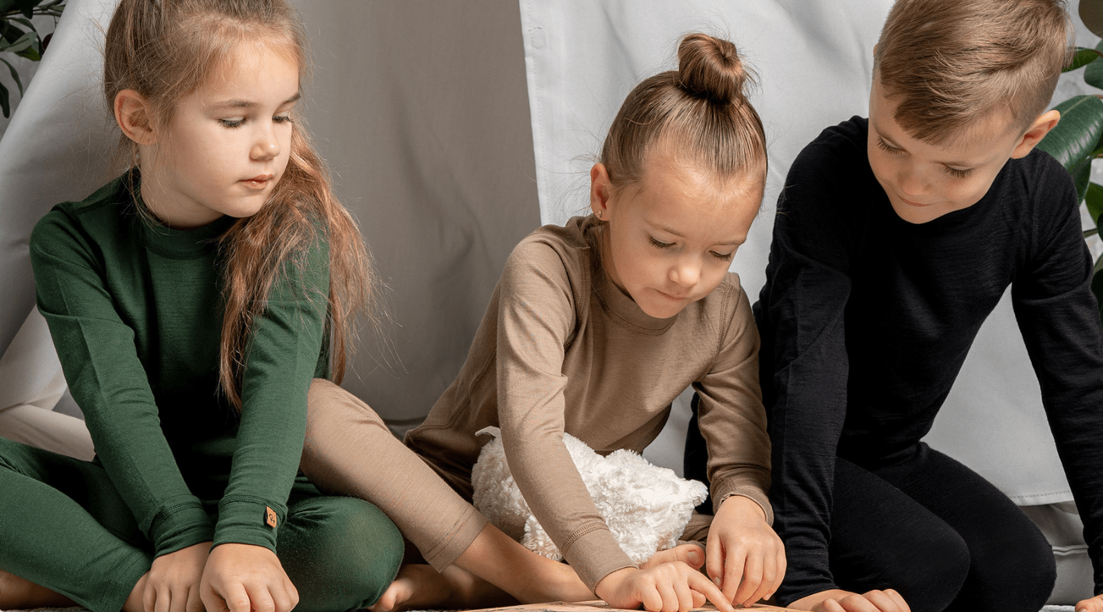 a girl sitting in a mustard yellow armchair, wearing a royal cherry color clothing set made from merino wool fabric.