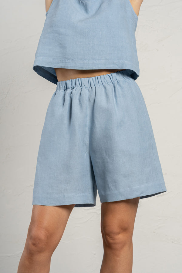 Linen Bermuda shorts in the color cloudy blue. High-waisted longer shorts with pockets and elastic waistband.