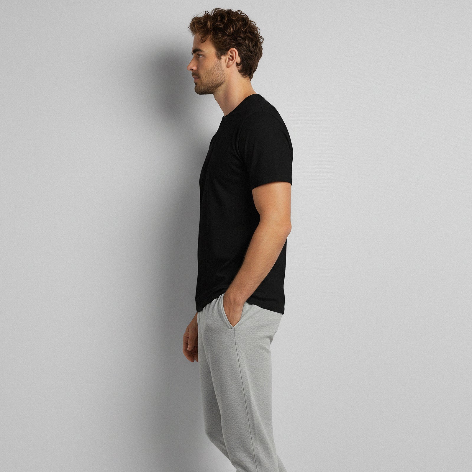 Man wearing a black bamboo t-shirt and gray pants, standing in a relaxed pose.