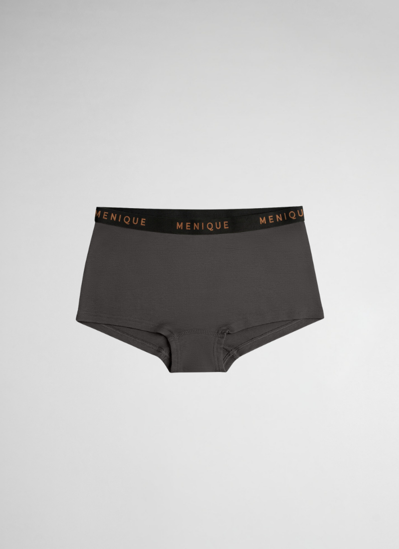 A pair of dark grey boyshort-style underwear is displayed flat against a plain, light grey background. The garment features a contrasting thick black elastic waistband with the brand name "MENIQUE" written repeatedly in brown text.