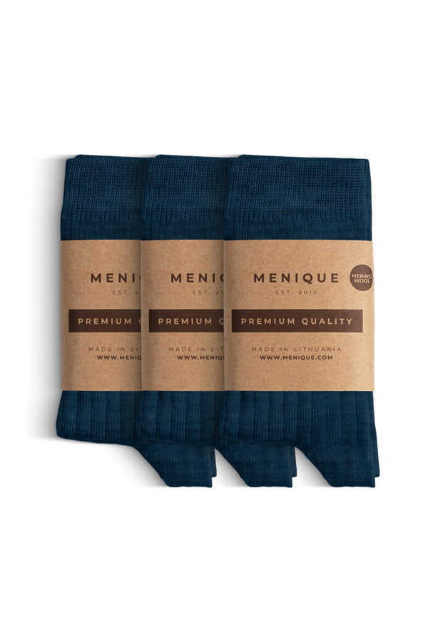 Een 3-pack donkerblauwe geribbelde merinowollen sokken voor kinderen met labels "Menique Premium Kwaliteit".