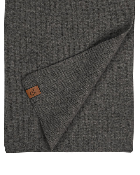 A rectangular dark gray knitted scarf, folded, revealing a small brown leather tag with an embossed logo in the corner, set against a white background.