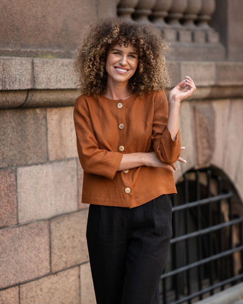 Woman with curly hair wearing Almond Brown linen jacket Alice