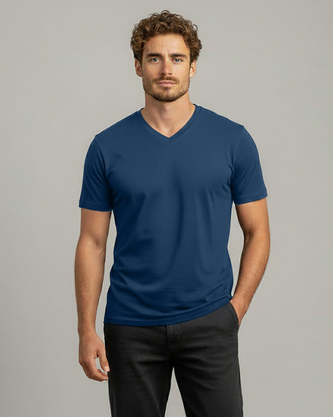 Man wearing a blue V-neck t-shirt against a gray background