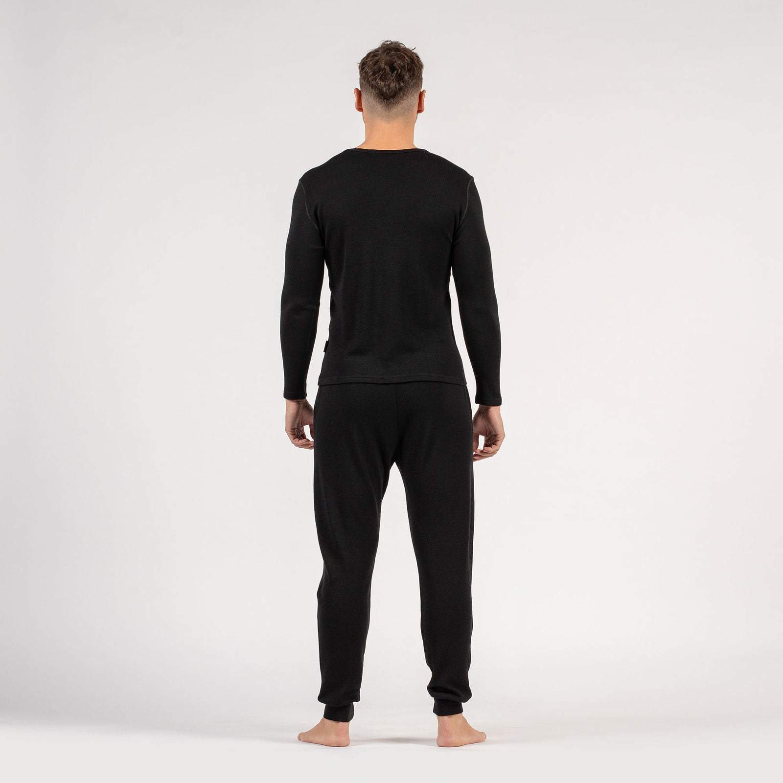 De menique heren merinowollen longsleeve van 250 g/m² en joggingbroek set in zwarte kleur.