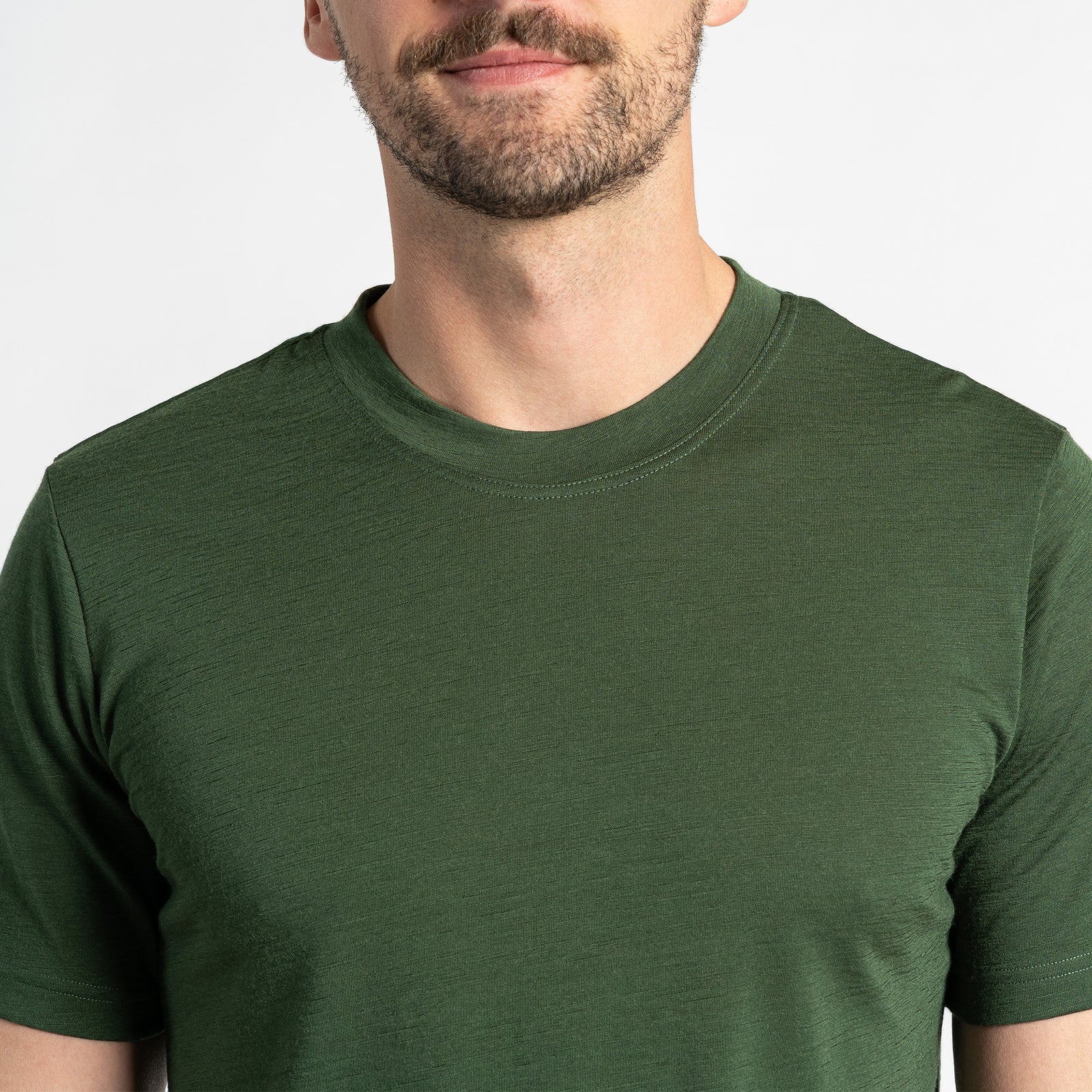 Two men’s short sleeve dark green Merino wool t-shirts, breathable and odor-resistant, designed for comfort and versatility.