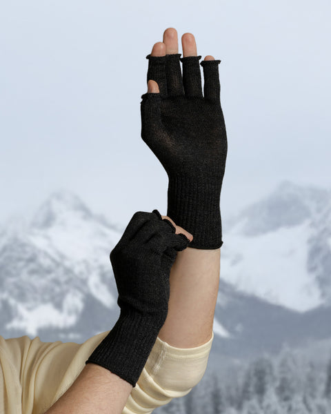 Detail view of dark gray merino wool fingerless gloves highlighting ribbed cuffs and soft knit texture