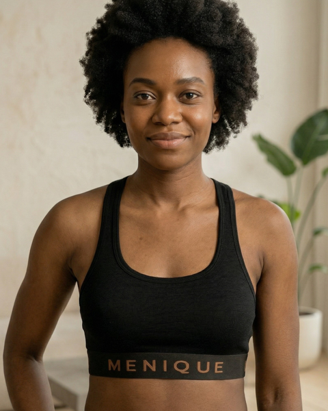 Woman wearing a black merino wool sports bra, front view