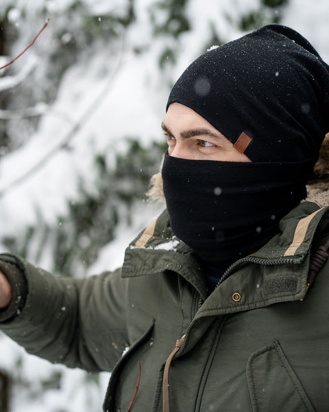 Menique Men's Merino Beanie and Gaiter Accessory Set worn by a man, in winter time. The set is in black color.