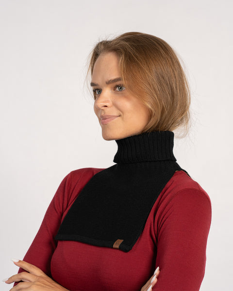 Woman wearing a black knitted merino wool dickie neck warmer over a red top, front view.