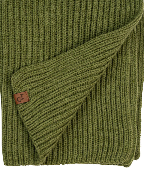 A close-up flat lay of an olive green ribbed knit scarf. A corner of the hem is folded up diagonally, displaying a small, square brown leather logo patch. The thick ribbed texture is clearly visible against the white background.