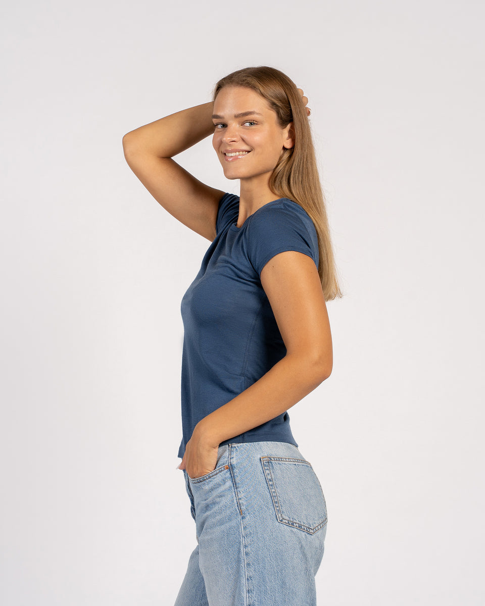 Zijaanzicht van model dat een denim Merino T-shirt draagt – zacht, lichtgewicht wollen shirt