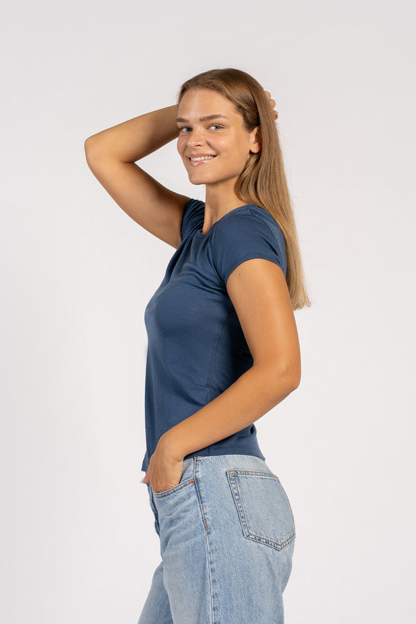 Zijaanzicht van model dat een denim Merino T-shirt draagt – zacht, lichtgewicht wollen shirt