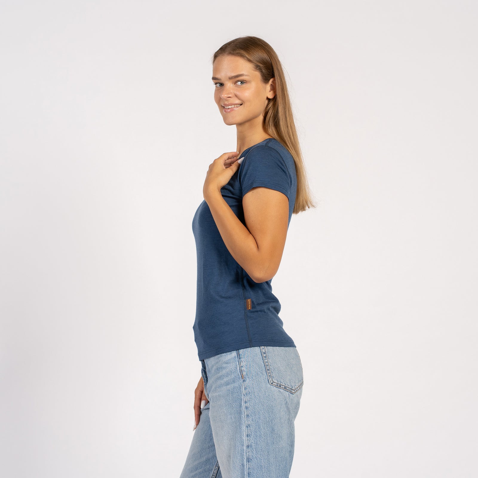 Vrouw die lacht in een denimblauw Merinowollen T-shirt met V-hals en korte mouwen.