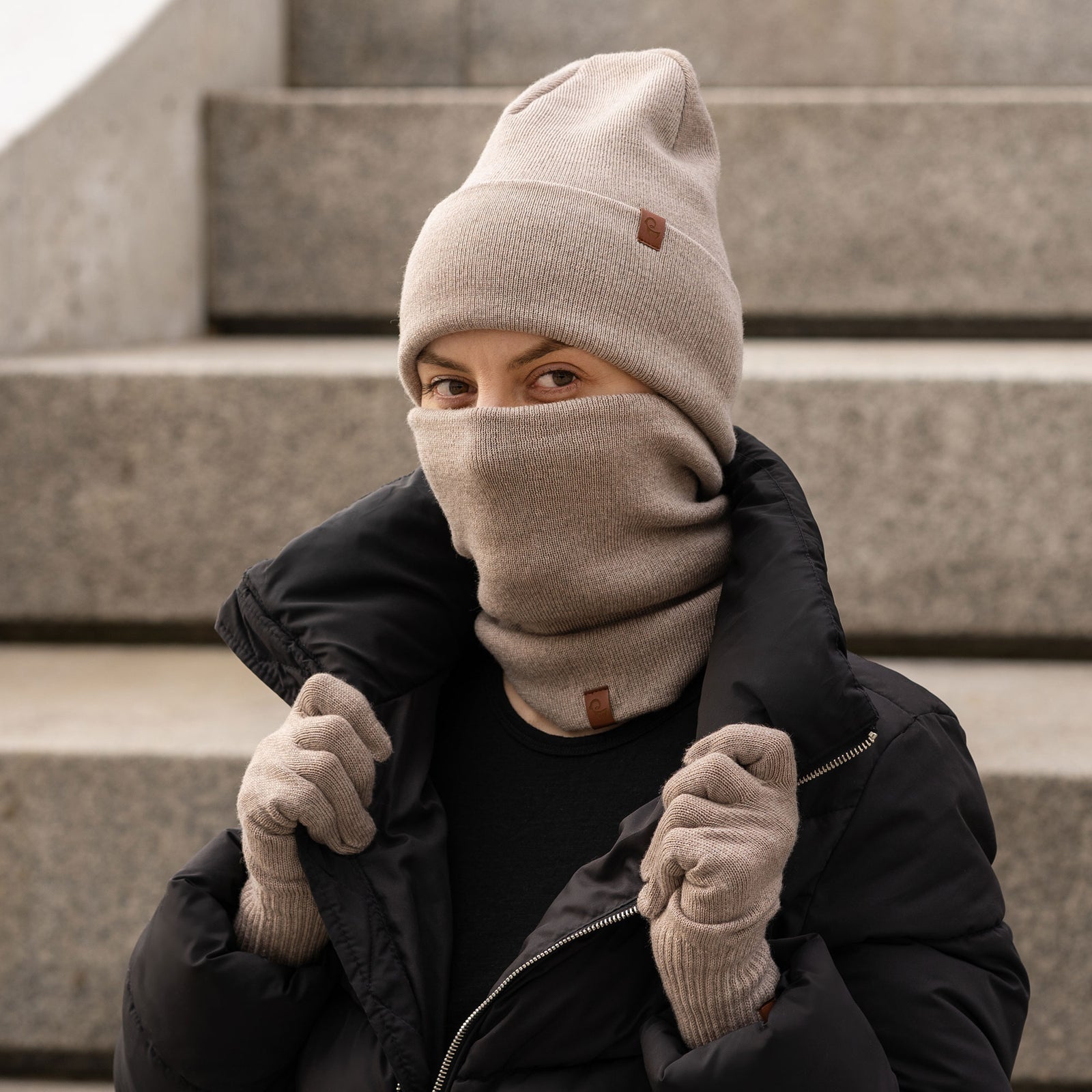 Woman wearing dark gray Merino wool knit neck gaiter and matching beanie, winter thermal face and neck warmer.