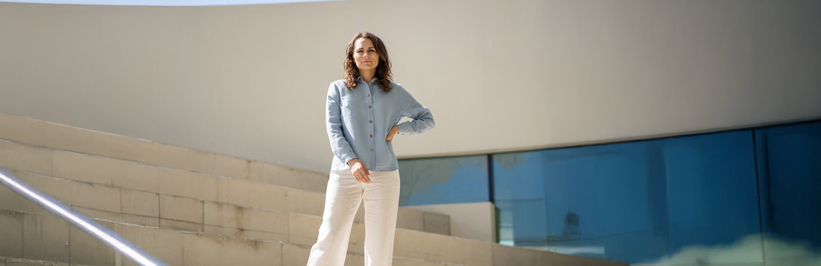 Vrouw staand op een trap met een modern gebouw op de achtergrond