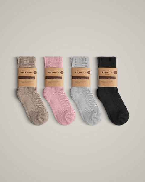 The menique kids' merino wool thick ribbed socks in all available colors, with packaging.