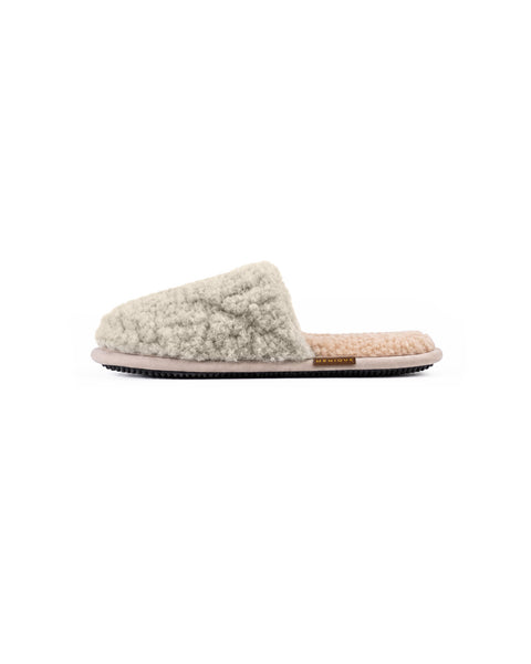 A side view of a single light gray fuzzy slip-on slipper with a beige insole, a flat black sole, and a brown "MENIQUE" tag on the side.